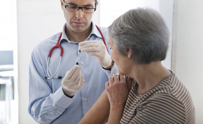 Bác sĩ tiêm vắc xin cho người già